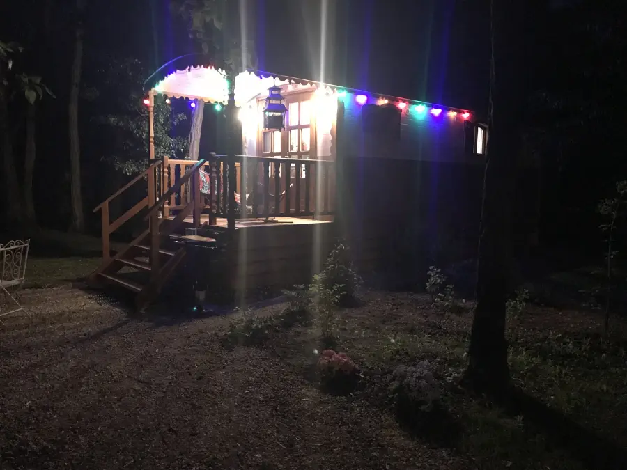 The roulotte lit with coloured lights, after dark